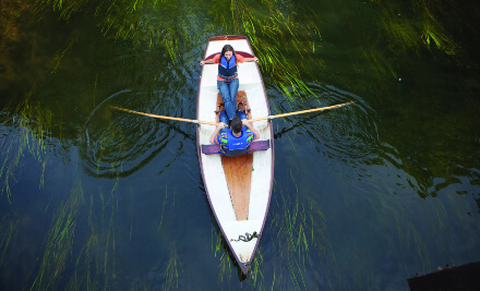 Rowing boat in water with 2 passengers