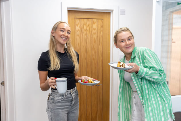 Two females with a plate with cake