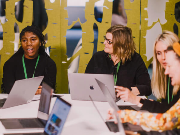 John Lewis Partnership employees working together at a table with laptops